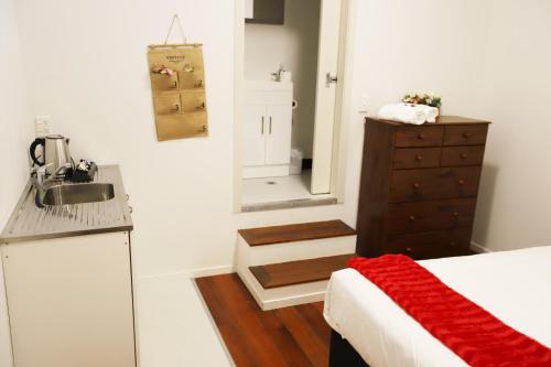 bagno con lavandino, letto e specchio di Aura Hotel a Wellington