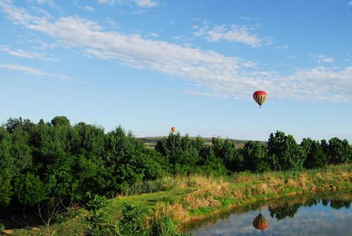 a hot air balloon is flying over a river at Wonderland in Winterton