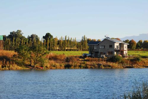 a house on a hill next to a body of water at Wonderland in Winterton