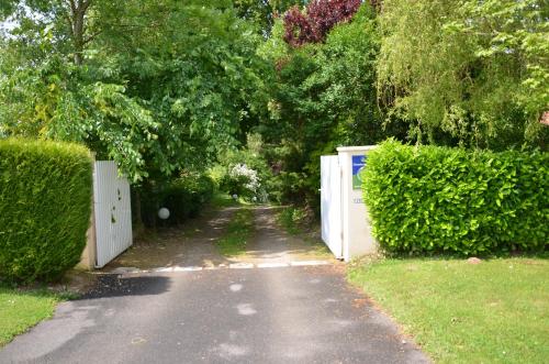 a driveway with two white doors and a hedge at La Villa Antalya in Ault