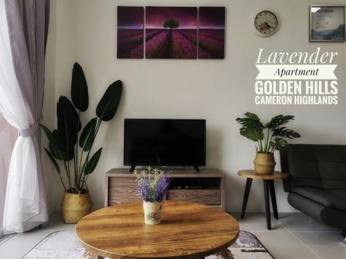 ein Wohnzimmer mit einem Tisch und einem TV in der Unterkunft Lavender Apartment 1BR Golden Hills Cameron Highlands in Cameron Highlands