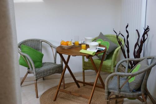 a table with two chairs and a bowl of fruit on it at La Villa Antalya in Ault