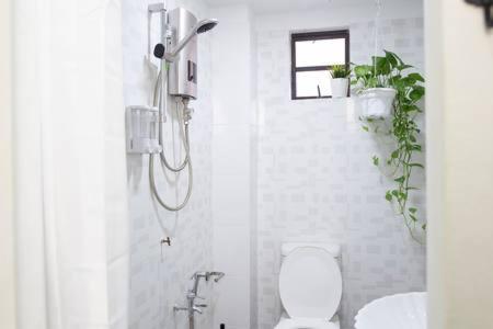 a bathroom with a toilet and plants on the wall at Omar's Place 1 in Kuala Lumpur