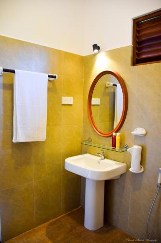 a bathroom with a sink and a mirror at Tenasi Beach Resort in Ahangama
