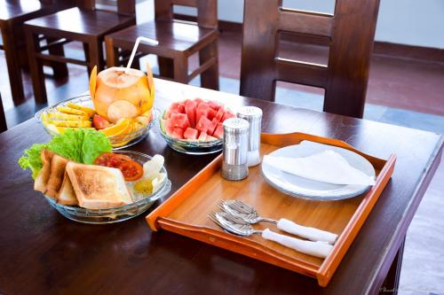 un tavolo in legno con un vassoio di cibo sopra di Tenasi Beach Resort ad Ahangama