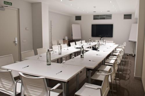 a large room with tables and chairs and a flat screen tv at Ibis Lleida in Lleida