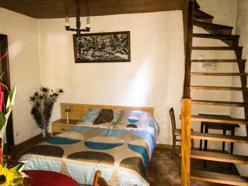 a bedroom with a bed and a spiral staircase at Studio duplex 1 Lac des Montagnès in Mazamet