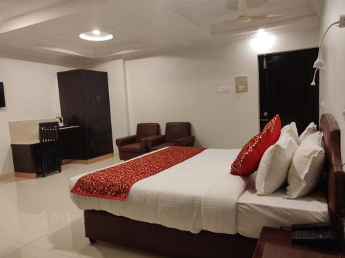 a hotel room with a bed and a chair at Chandra Inn in Jodhpur