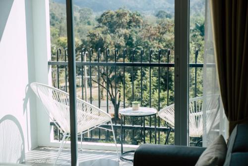 a balcony with two chairs and a table and a window at Courtyard khaoyai by JP in Mu Si