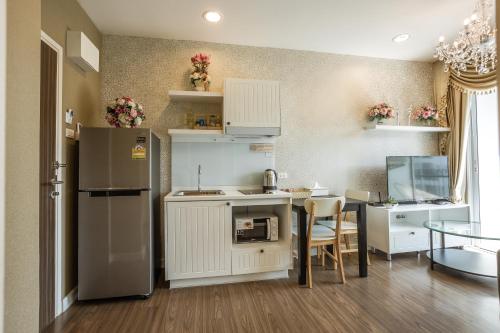 a small kitchen with a refrigerator and a table at Courtyard khaoyai by JP in Mu Si