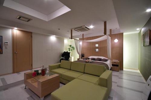 a living room with a couch and a bed at Hotel agehA cinq boutique (Adult Only) in Okayama