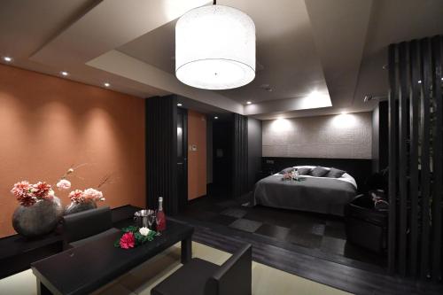 a hotel room with a bed and a living room at Hotel agehA cinq boutique (Adult Only) in Okayama