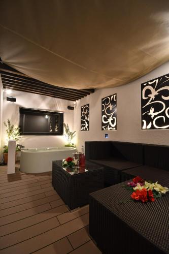 a living room with two couches and a tv on the wall at Hotel agehA cinq boutique (Adult Only) in Okayama