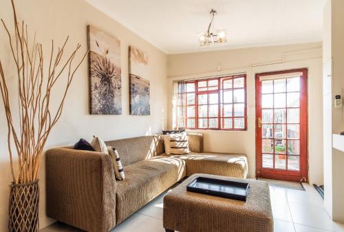 a living room with a couch and a table at Treetops Guesthouse in Port Elizabeth