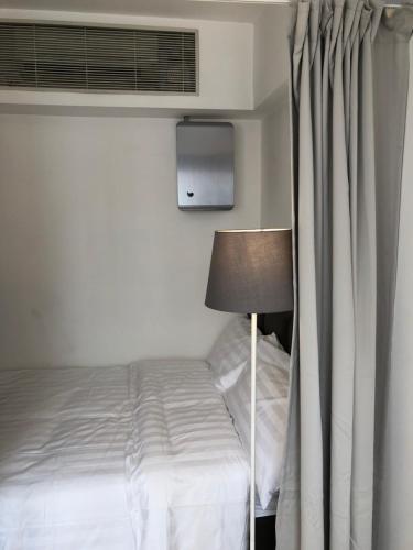 a bedroom with a bed with a window and a lamp at Homy Residence in Hong Kong