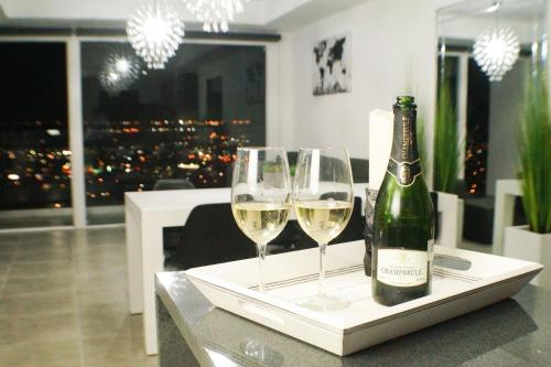 a bottle of wine and two wine glasses on a table at Luxurious Condo & unparalleled Comfort inTijuana in Tijuana