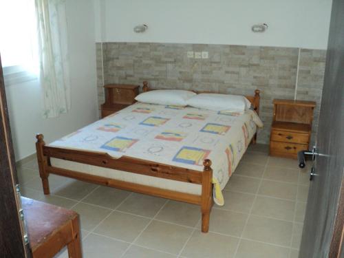 1 dormitorio con 1 cama con marco de madera en Katerina Apartments en Kokkíni Khánion