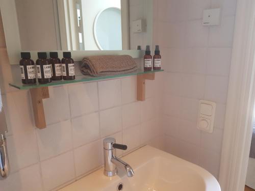 a bathroom with a sink and a mirror and bottles at Örum 119 in Löderup