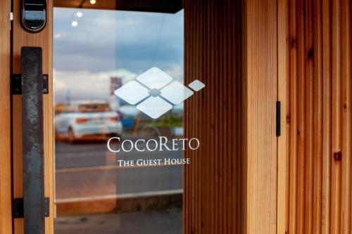a door with a sign that reads colectivo the guest house at COCORETO The Guesthouse Daikon Island in Matsue