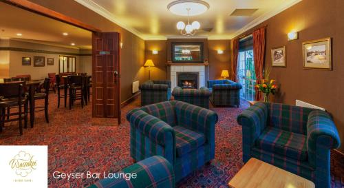 a living room with blue chairs and a fireplace at Wairakei Resort Taupo in Taupo