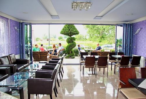 un restaurante con mesas y sillas y gente sentada en Enalion en Olympiakí Aktí