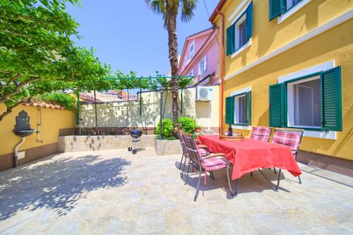 un patio con tavolo, sedie e un edificio di Little villa Tony- Center 40m beach Crikvenica a Crikvenica