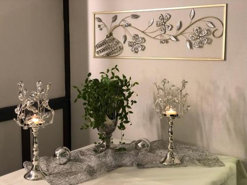 a table with two vases and a plant on it at Hotel & Restaurant Blume in Wolfsburg
