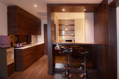a kitchen with a bar with stools in it at Mercure Karawang in Karawang