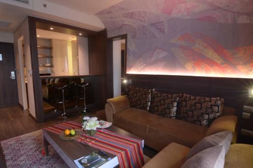 a living room with a couch and a table at Mercure Karawang in Karawang
