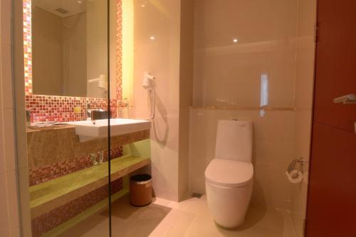 a bathroom with a toilet and a sink at Mercure Karawang in Karawang