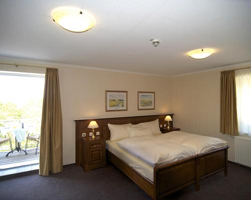 ein Schlafzimmer mit einem Bett und einem großen Fenster in der Unterkunft Waldhotel Rheinbach in Rheinbach