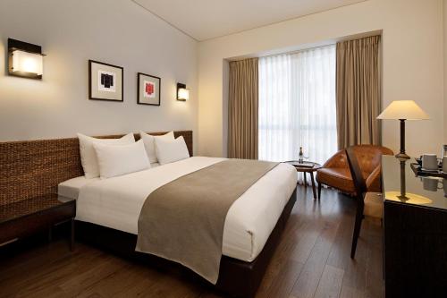 a hotel room with a large bed and a window at Vital - Urban boutique hotel TLV in Tel Aviv
