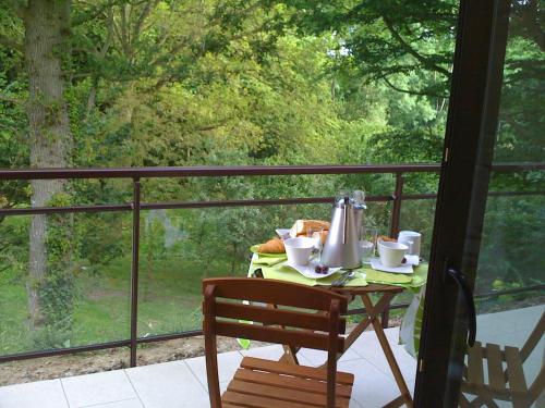 a table with a tea kettle and cups on a balcony at La Villa Antalya in Ault