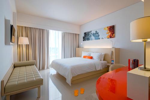 a hotel room with a bed and a chair and a desk at HARRIS Hotel and Conventions Denpasar Bali in Denpasar
