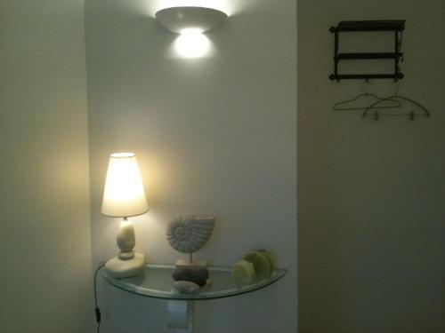 a room with a lamp and a shelf with shells at La Villa Antalya in Ault