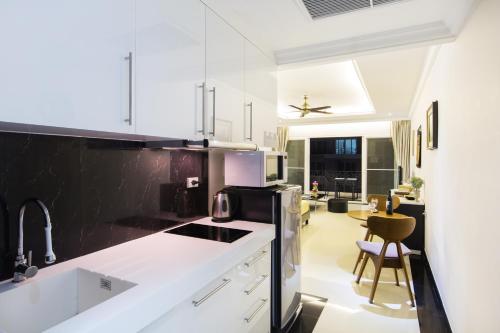 uma cozinha com armários brancos e electrodomésticos a preto e branco em Beautiful Apartment D6 Central Pattaya em Pattaya Central