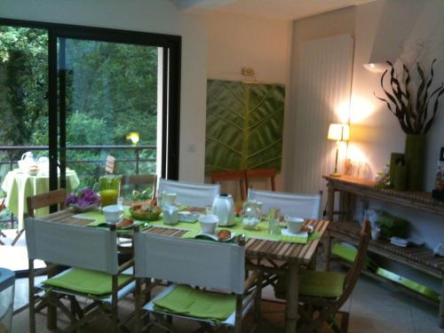 a dining room with a table with chairs and a fireplace at La Villa Antalya in Ault