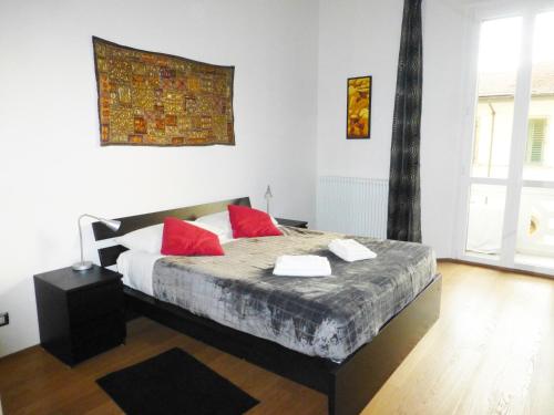 een slaapkamer met een bed met rode kussens erop bij Casa "Le Cascine", comfortable apartment... in Florence