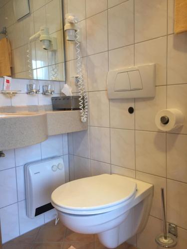 a bathroom with a white toilet and a mirror at Stumbergers Hotel in Cochem