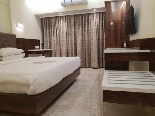 a bedroom with a large bed and a sink at Hotel Milan International in Mumbai