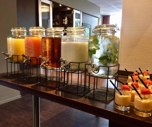a group of jars filled with different types of drinks at Fletcher Hotel Restaurant Boschoord in Oisterwijk