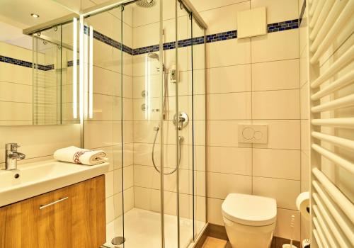 ein Bad mit einer Dusche, einem WC und einem Waschbecken in der Unterkunft Landhotel Geyer in Kipfenberg