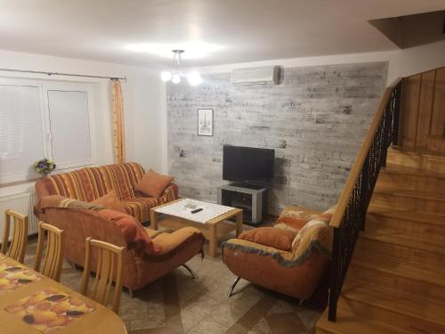 uma sala de estar com dois sofás e uma televisão em Villa Rose em Veľký Meder