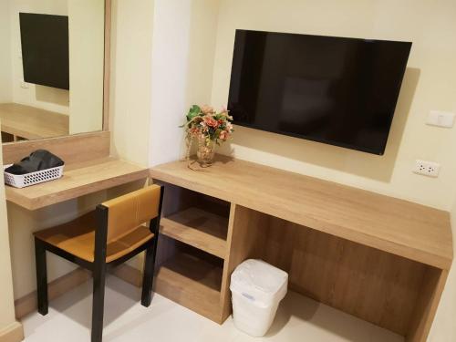 a room with a desk with a television and a chair at OMG Hotel in Khon Kaen