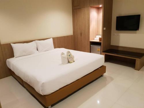 a bedroom with a large white bed with a tv at OMG Hotel in Khon Kaen