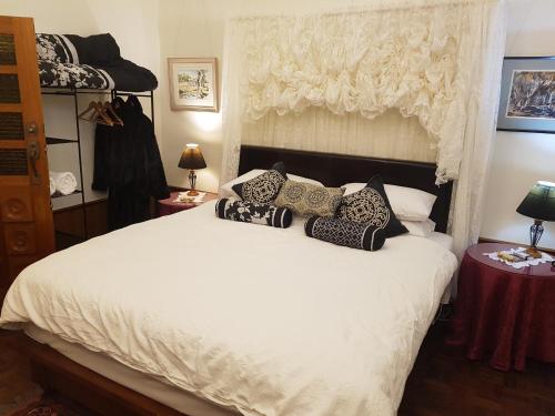 a bedroom with a white bed with pillows on it at Barossa Glen ~ Henri's Cottage ~ Bed & Breakfast in Rosedale