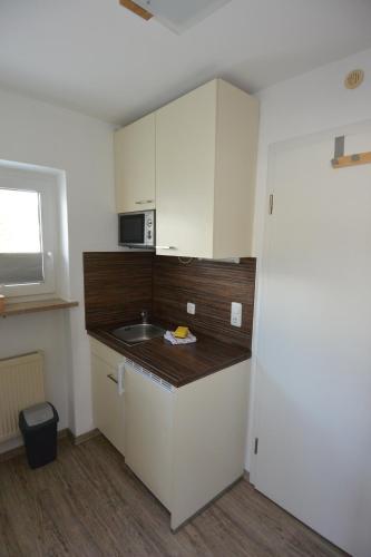 a small kitchen with a sink and a microwave at Haus Erli in Mittenwald