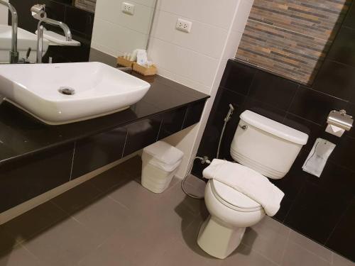 a bathroom with a white toilet and a sink at OMG Hotel in Khon Kaen