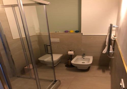 uma casa de banho com um chuveiro, um WC e um lavatório. em Relais Al Porto em Peschiera del Garda