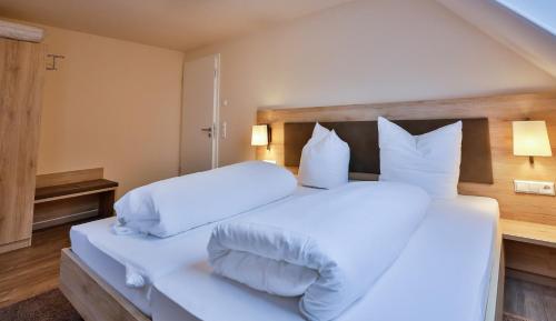 a bedroom with two beds with white sheets and pillows at Hotel Ochsen in Ammerbuch